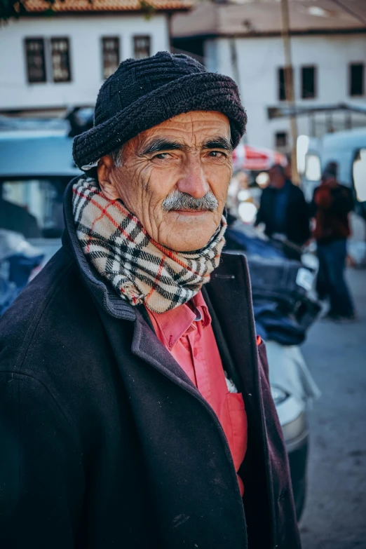 old man with a mustache standing on the street