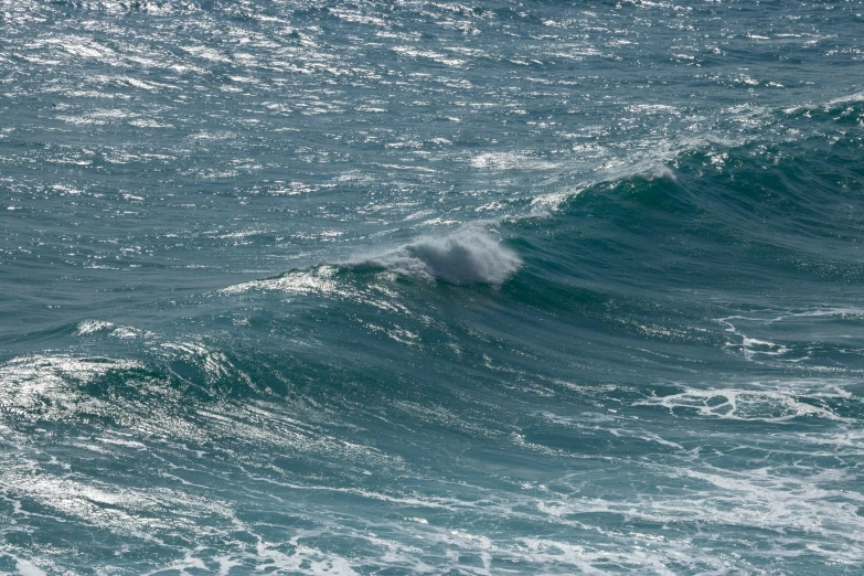 a lone bird flying over the water while riding a wave