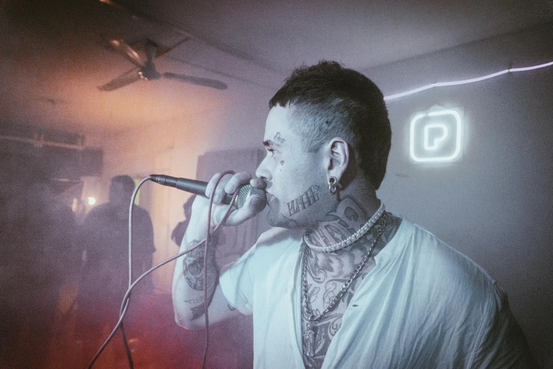 a man talking on the telephone while standing in front of a microphone