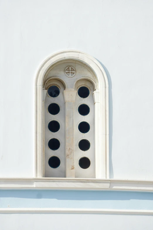 a circular window on the side of a white building