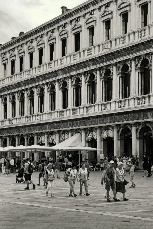 the people are walking near a building with arches