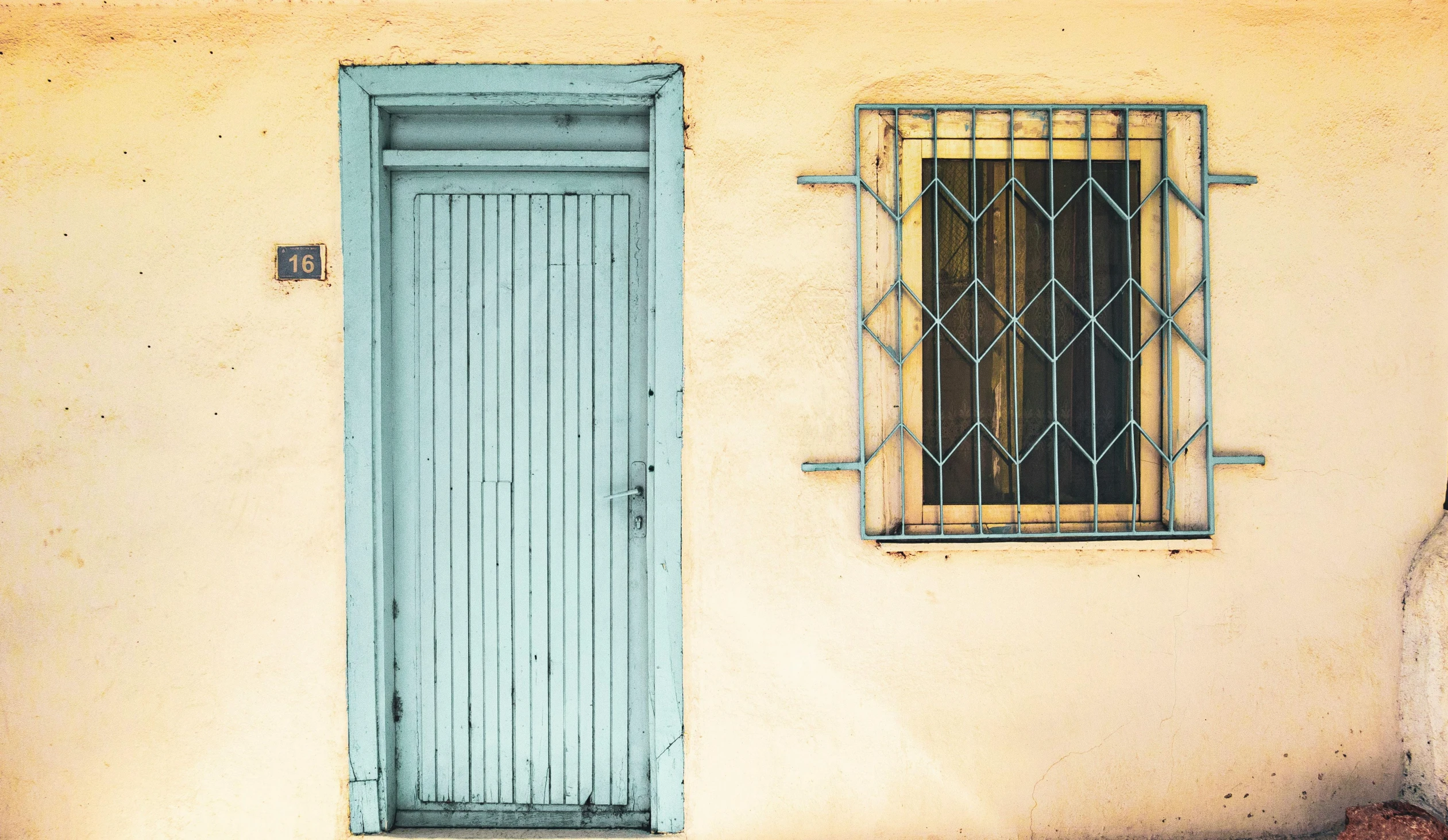 a blue shuttered window and a window sill on a stucco building