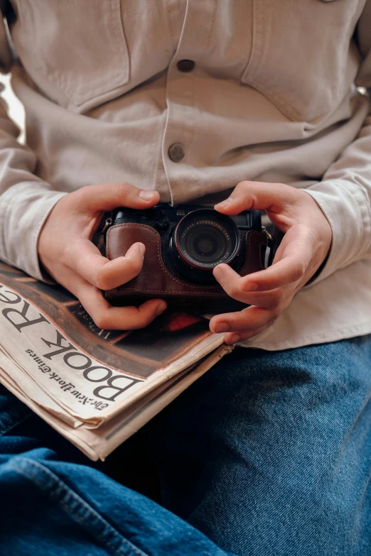 someone sitting on a chair with a camera in their hands