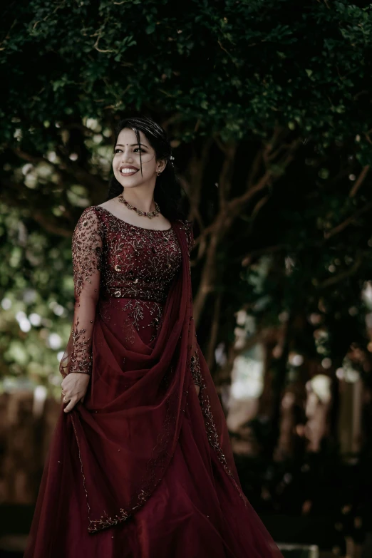 a woman in an intricately dd maroon gown