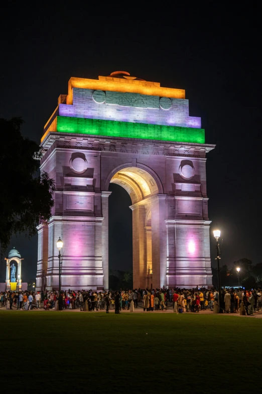 people standing around a stone archway on a park