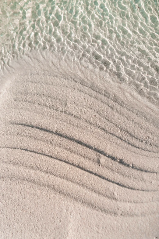 the white sand is forming a pattern on the beach