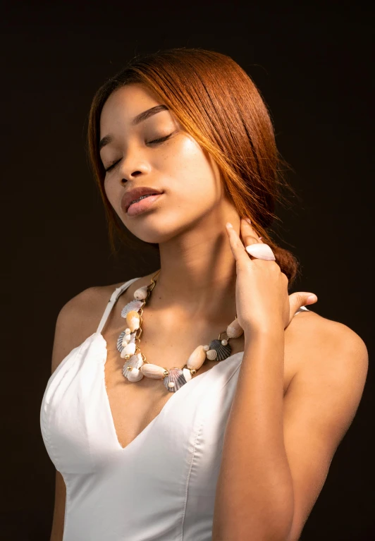 a young woman with her eyes closed wearing a necklace