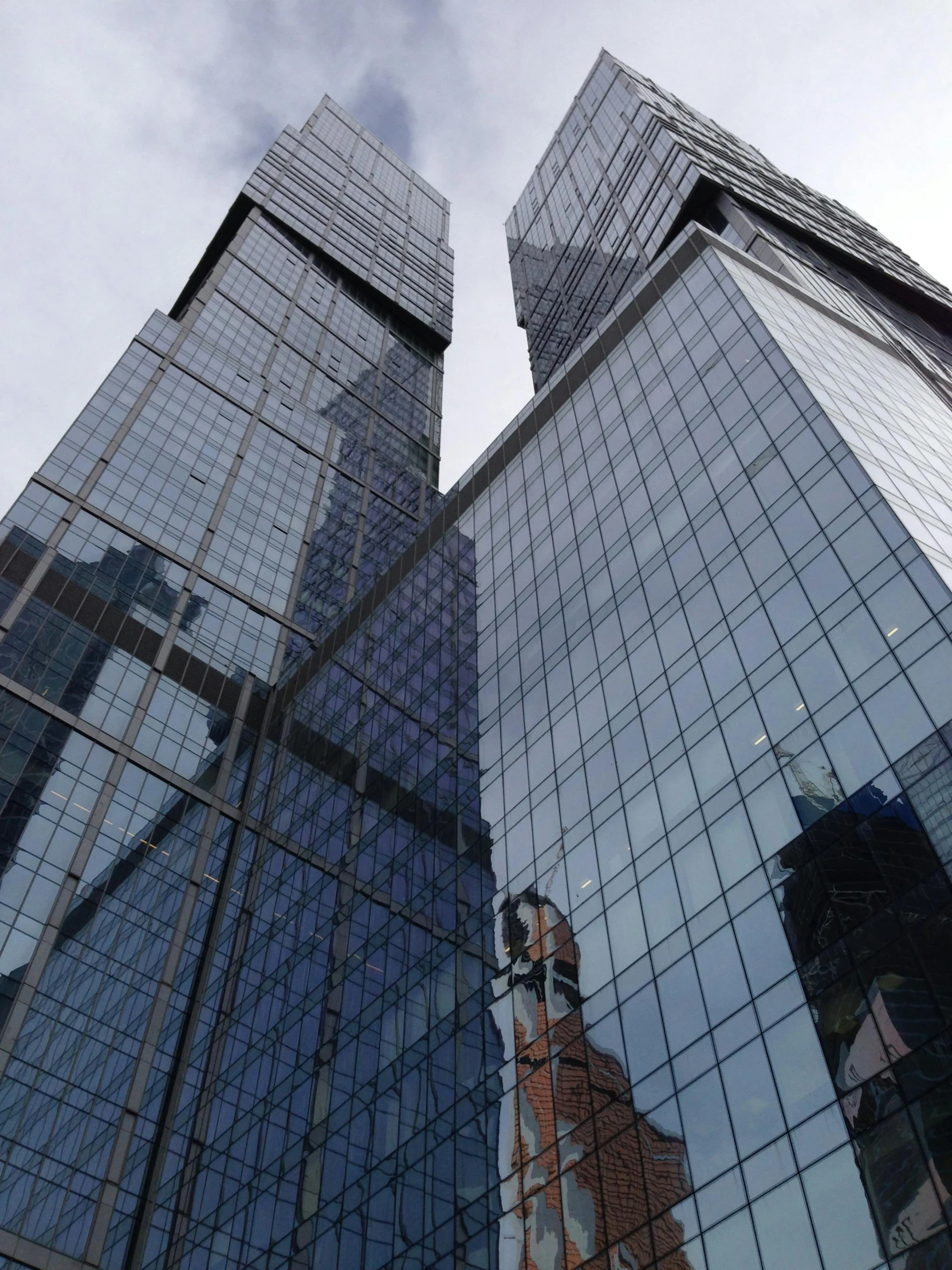 three tall building's reflecting each other in mirrored windows