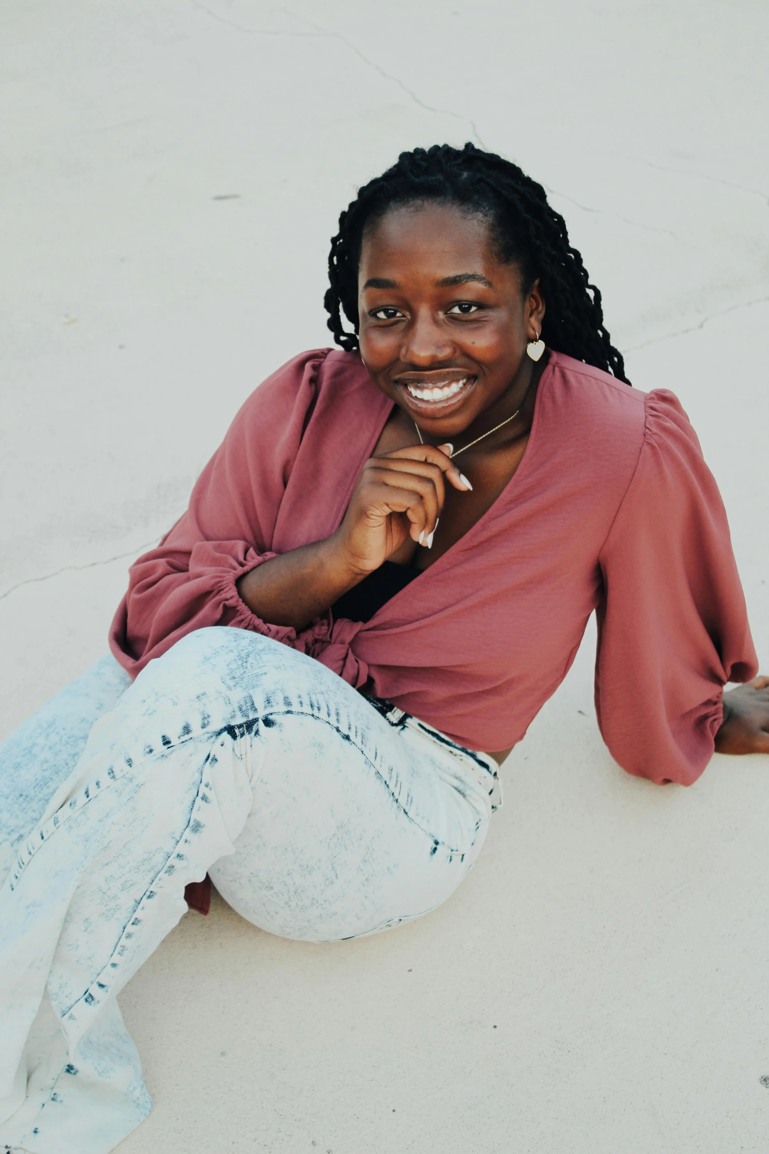 a person with a smile sits on the ground