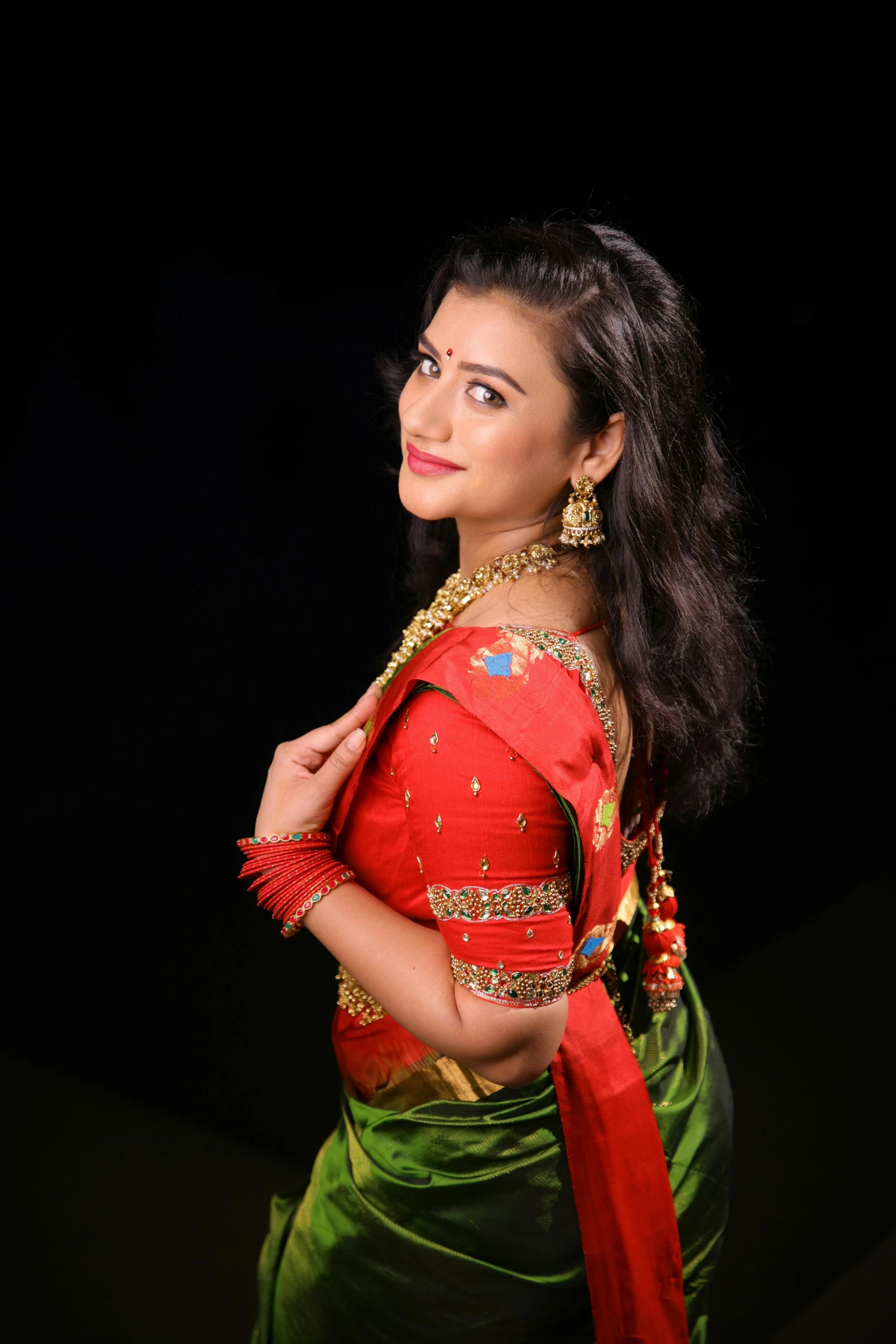 a woman in a red and green dress poses for a po