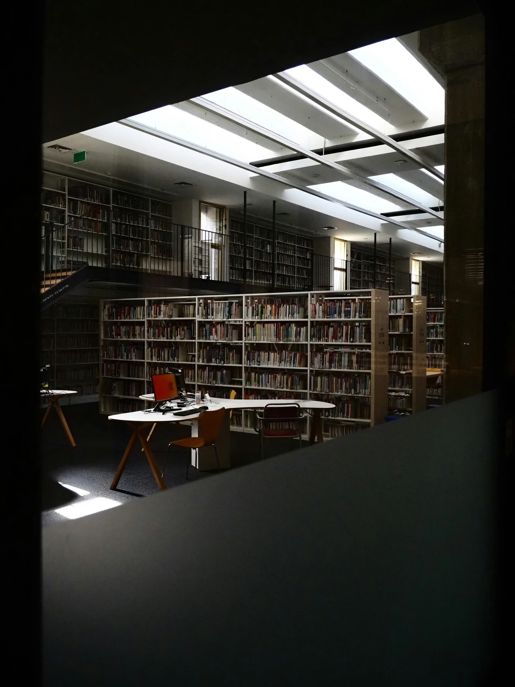 a view through an open window of the liry and its lights are on