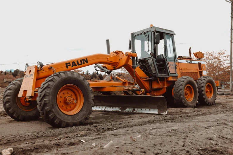 there is a orange bulldozer in a lot