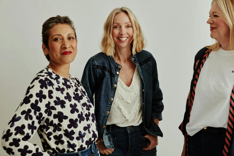 two women with a scarf around her neck standing next to another woman