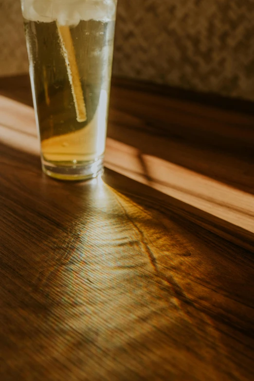 glass of iced tea on wood table with sunlight coming through window