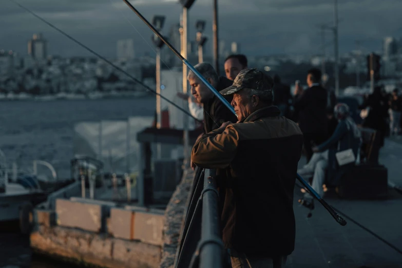 several people with poles on a boat in the ocean