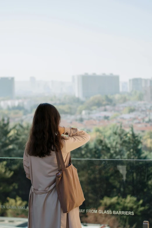 a girl is standing by a window with the view