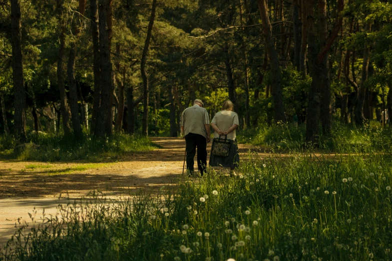 two people walking down a trail carrying luggage