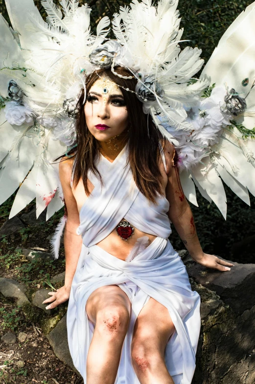 a girl is dressed in white and wings