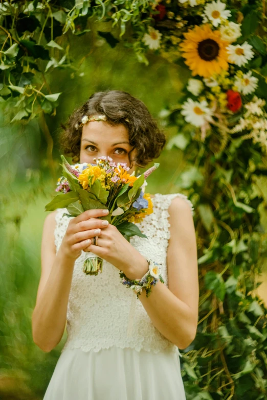 a woman holding flowers in front of her face