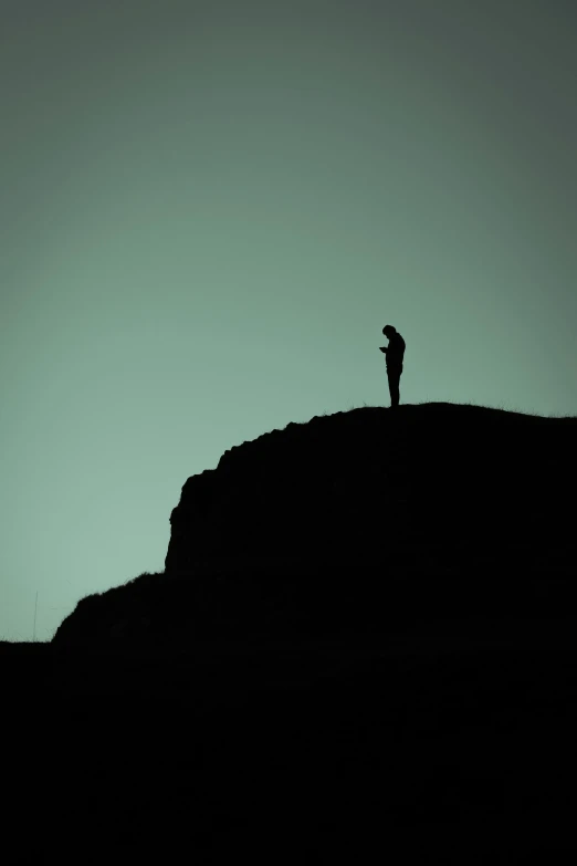 silhouette pograph of a person on top of a mountain