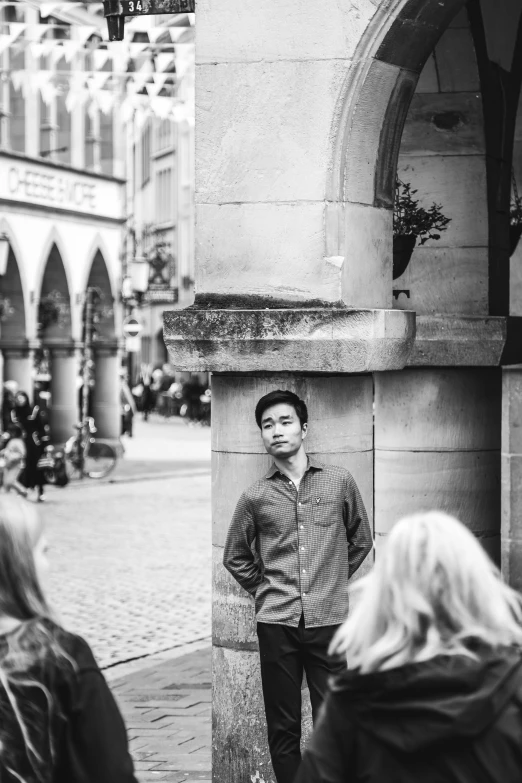 black and white pograph of a man in front of a statue