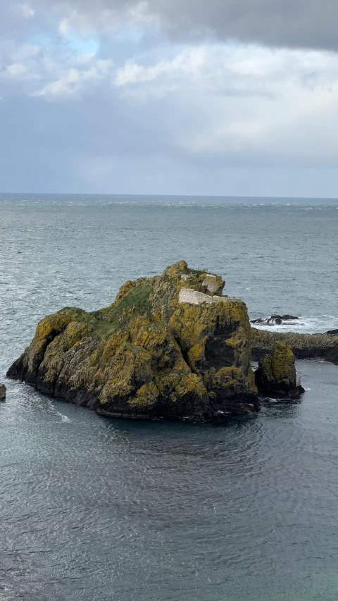 the rocky island has a lighthouse sticking out of it