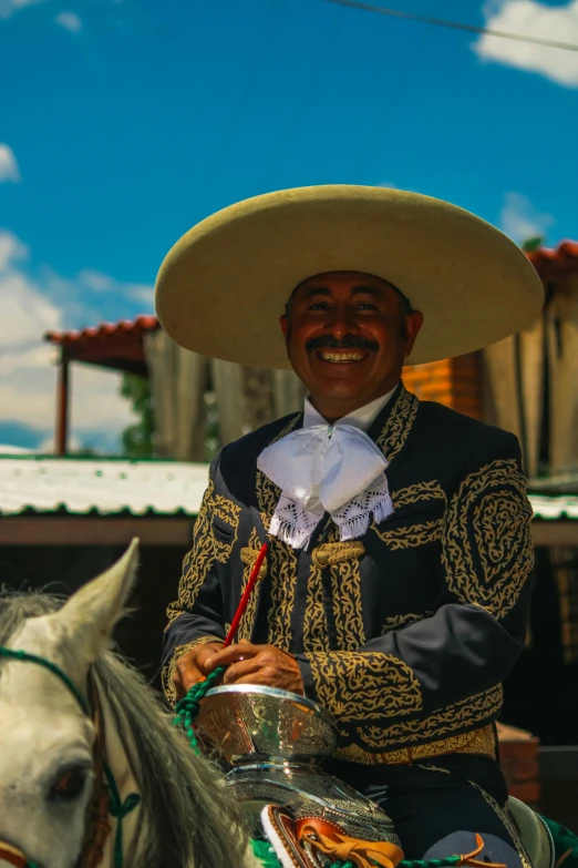 a mexican man riding a horse wearing a hat