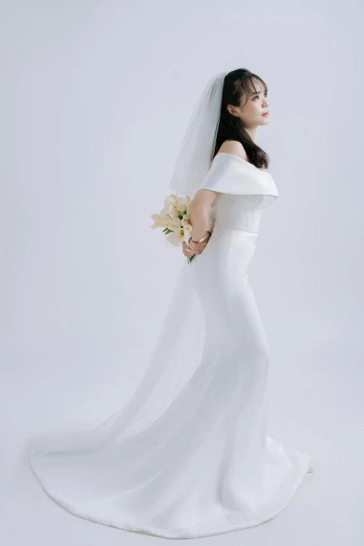 a woman in a white dress stands with her arms on the back of her dress