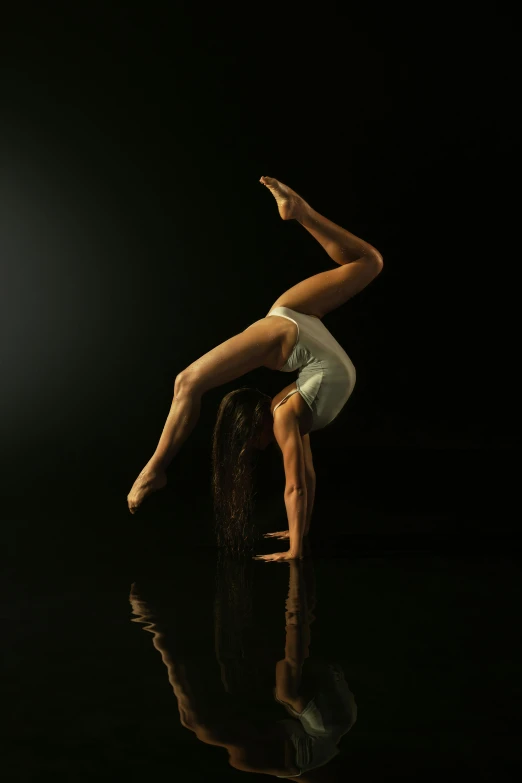 a man performs a handstand on top of an object