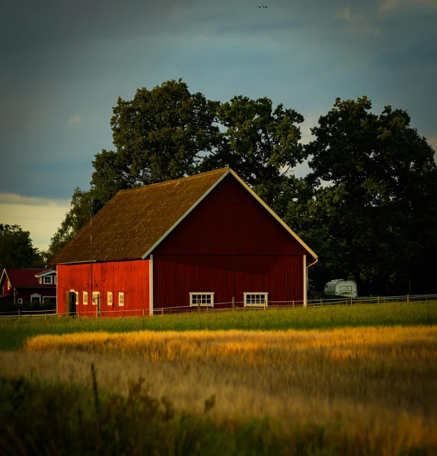 a red barn sitting next to trees and a field