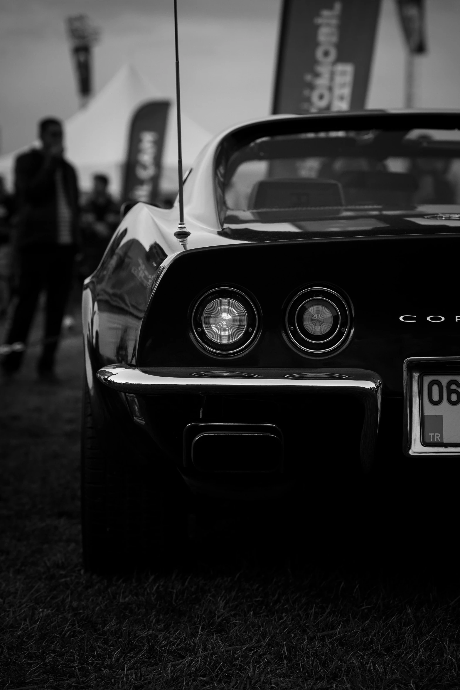 a classic car sits parked in front of a crowd