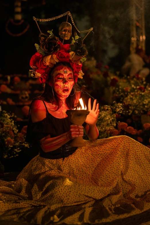 a woman in her face painted holding a lit candle