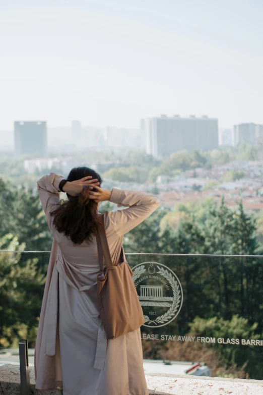 a woman with her back to the camera covering her ears