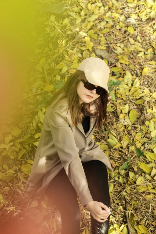 a woman is sitting on the ground and posing for a picture