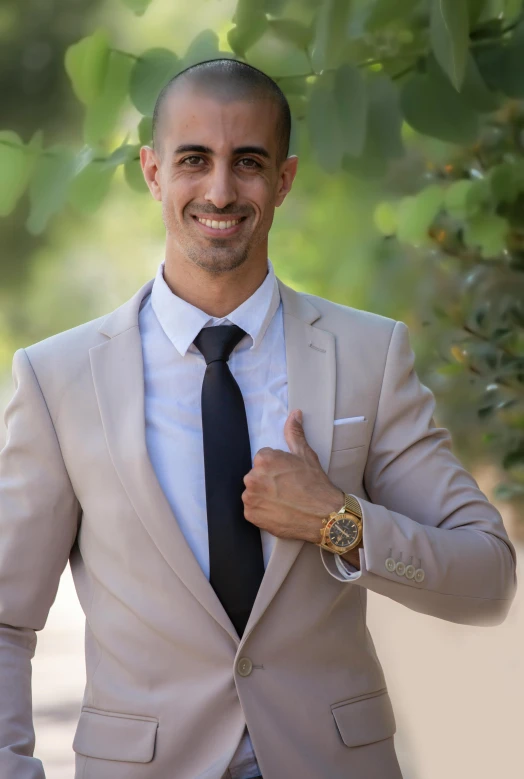 a man in a suit holding his hand up while wearing a watch