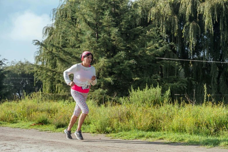 a woman jogging in the park along a dirt path