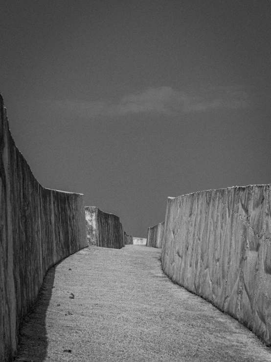 a stone bridge crossing over a dirt road