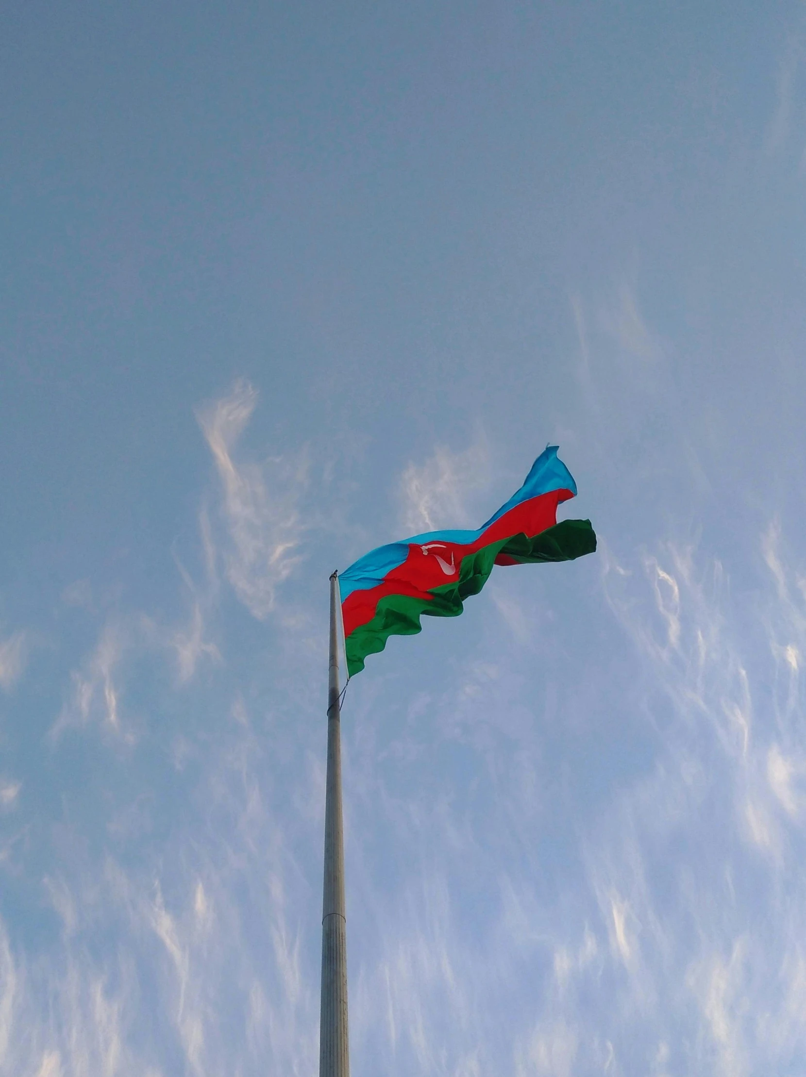 an airplane is flying above the flag pole