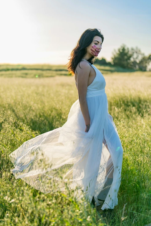 woman in a field with grass and sky in background