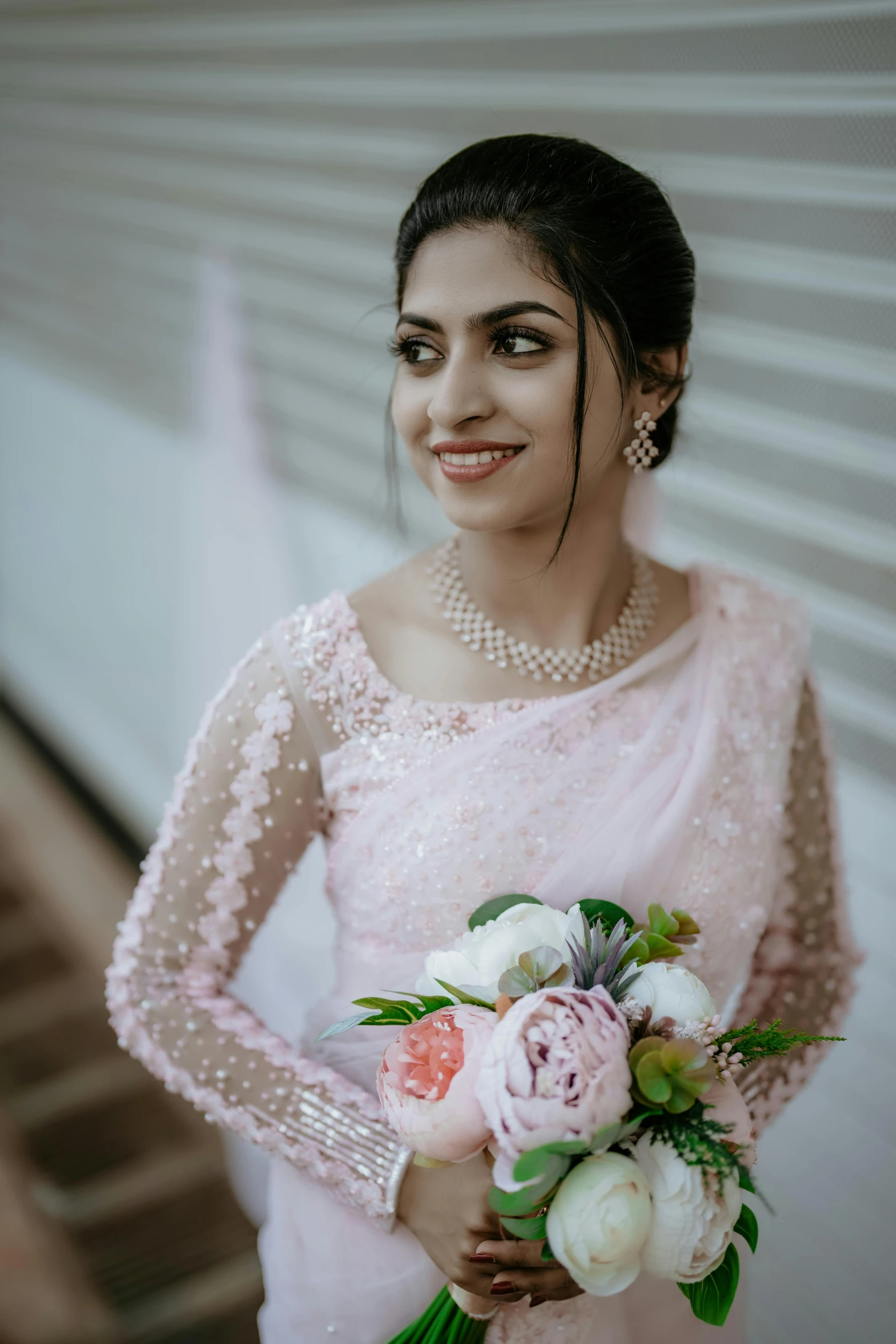 a woman in pink holding her bouquet and posing
