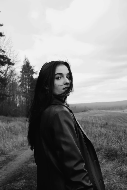 black and white pograph of woman with long hair in field