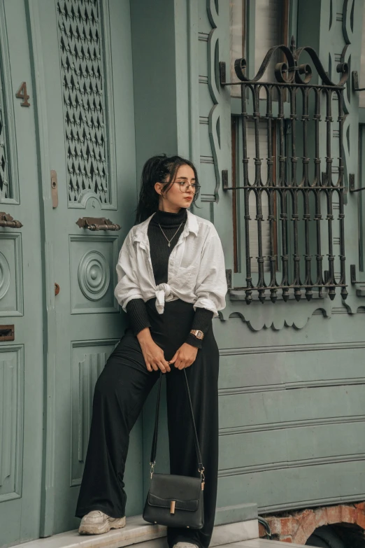 a woman sits in front of a blue door