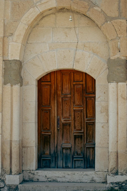 an open, dark wooden door on the outside of a stone building