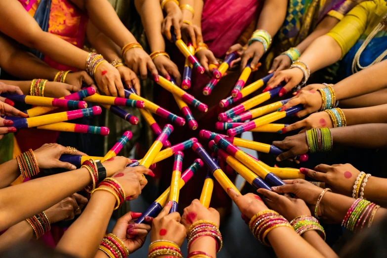 a group of women holding up colored sticks