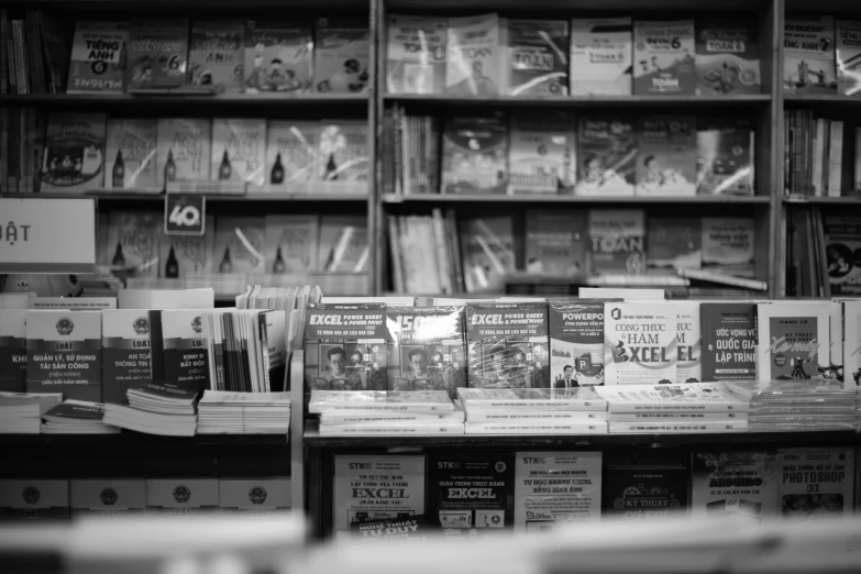 black and white image of several stacks of books in front of a book store