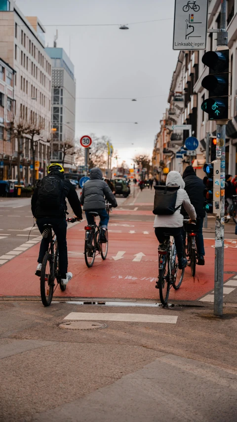 three bicyclists ride on the opposite lane in a bicycle crossing