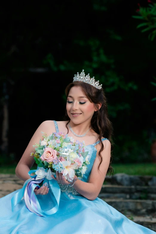a girl in a gown and tiara posing for a picture