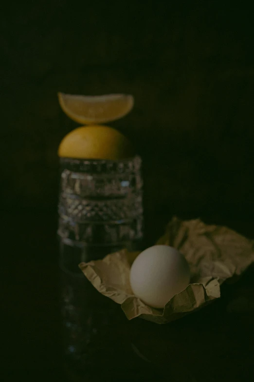 two eggs sitting in their cardboard holder with one being peeled