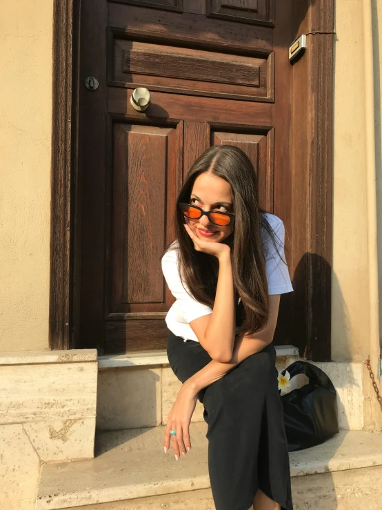 a young lady sitting on the steps posing for a picture