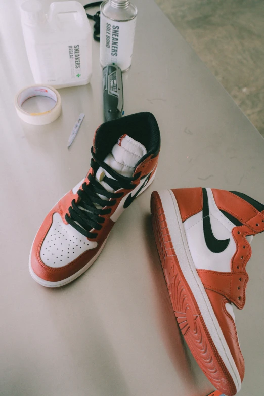 a pair of sneakers and a tube are on a table